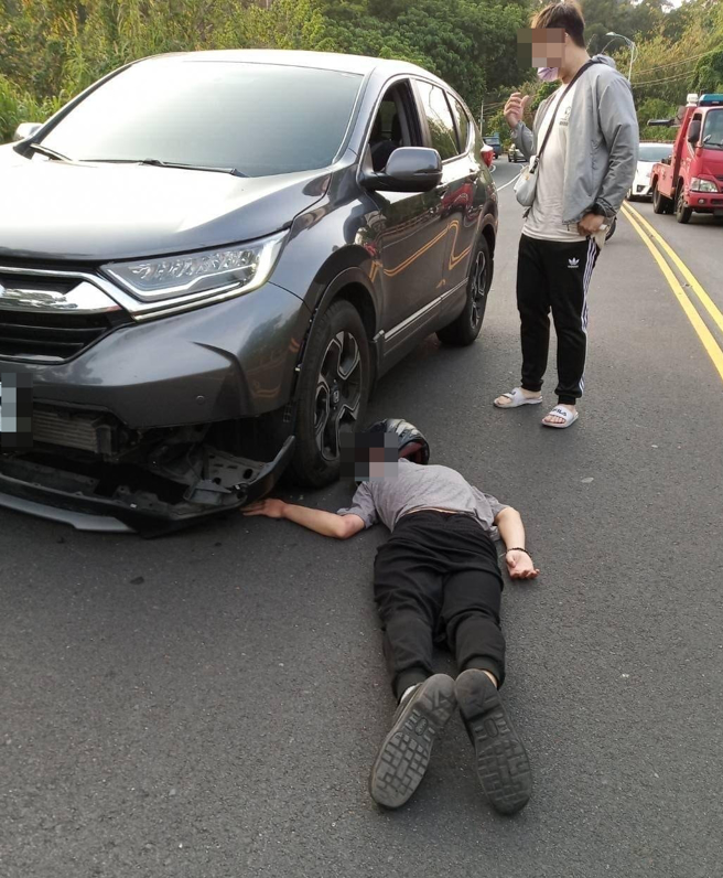 驾驶在山路遭对向机车骑士自摔后「钻进底盘」，他当下停车，所幸骑士保住一命，但左手臂疑似骨折，倒在地上时手臂呈现诡异角度，照片吓坏不少人。（翻摄自脸书「爆废公社公开版」）