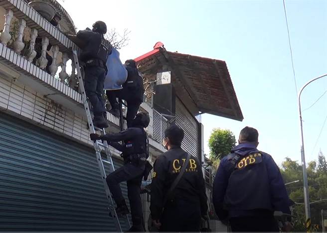刑事局中部犯罪打击中心破获地下签赌站，警方在搜索时为进入签赌站，还搭梯子进入。(林欣仪翻摄)