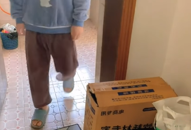 1段抖音影片近日被瘋傳，1名男子走在自家走廊，一旁紙箱竟突然伸出「1隻小手」接著1生物突然衝出嚇他，原來是家中的小貓。（翻攝自臉書「爆廢公社」）