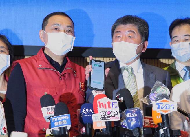 新北市13日確診數爆增至264例，新北市府內部共識，若全國個案數破千例時，將不再公布足跡，衛福部長陳時中（右）14日出席新北居家照護計畫全面啟動記者會時表示認同，陳認為疫情在社區傳播的時候，足跡公布意義已不大，並掏出手機鼓吹大家下載「台灣社交距離APP」，以後記者會大家都要出示才能進入，左則為新北市長侯友宜。（張鎧乙攝）