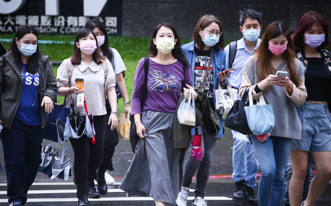 國內疫情嚴峻，民眾外出上班都緊戴口罩不敢鬆懈。（羅永銘攝）
