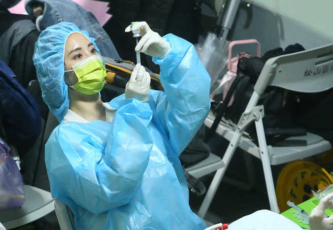 5至11岁儿童是否该施打疫苗，专家们看法不一。图为医护人员专注地抽取疫苗。（资料照／粘耿豪摄）