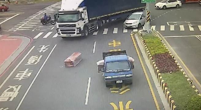 小货车左转内侧车道时，一副棺材疑似没有绑好，突然从车上滑落。（读者提供／张毓翎台南传真）