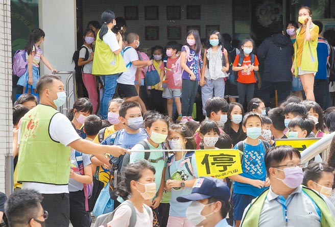 全台疫情大爆發，燒進校園，但各校的停課標準不一，形同一國多制。圖為台北市國小學生下課情形。（本報資料照片）