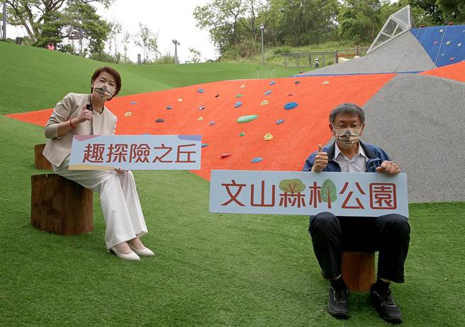 台北市長柯文哲（右）和副市長黃珊珊（左）15日出席文山森林公園開幕活動，開心拿著手牌和新開幕的公園合影留念。（趙雙傑攝）