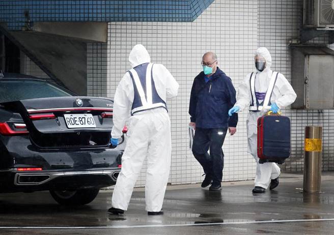 台湾NGO工作者李明哲（中）15日上午搭机返台，班机靠桥后在商务中心人员陪同下，从空桥直接走下机坪搭车离开。（范扬光摄）