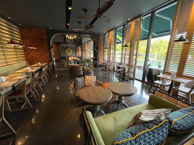 捷絲旅台南十鼓館1樓的「捷食藝」餐廳，設計感十足，落地窗外是戶外泳池景色。（何書青攝）