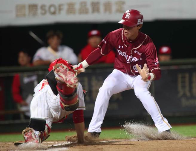 中華職棒15日味全龍對樂天桃猿之戰，桃猿陳晨威7局上藉著安打自2壘直闖本壘，跳在空中企圖躲開接球飛撲欲觸殺的味全捕手吉力吉撈未成，掉落在吉力吉撈的身上遭到觸殺出局。（鄭任南攝）