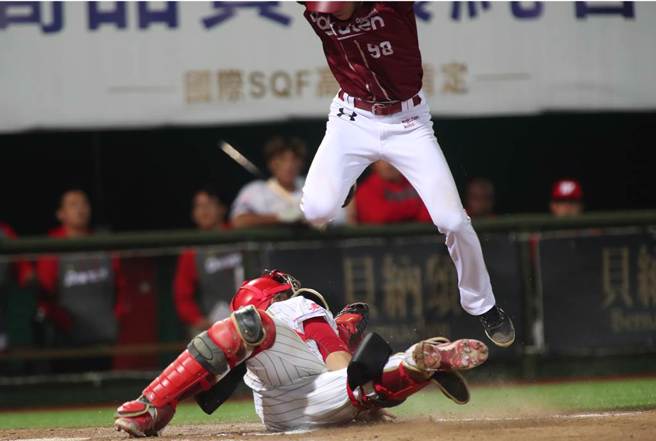 中華職棒15日味全龍對樂天桃猿之戰，桃猿陳晨威7局上藉著安打自2壘直闖本壘，跳在空中企圖躲開接球飛撲欲觸殺的味全捕手吉力吉撈未成，掉落在吉力吉撈的身上遭到觸殺出局。（鄭任南攝）