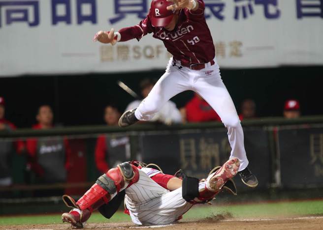 中華職棒15日味全龍對樂天桃猿之戰，桃猿陳晨威7局上藉著安打自2壘直闖本壘，跳在空中企圖躲開接球飛撲欲觸殺的味全捕手吉力吉撈未成，掉落在吉力吉撈的身上遭到觸殺出局。（鄭任南攝）