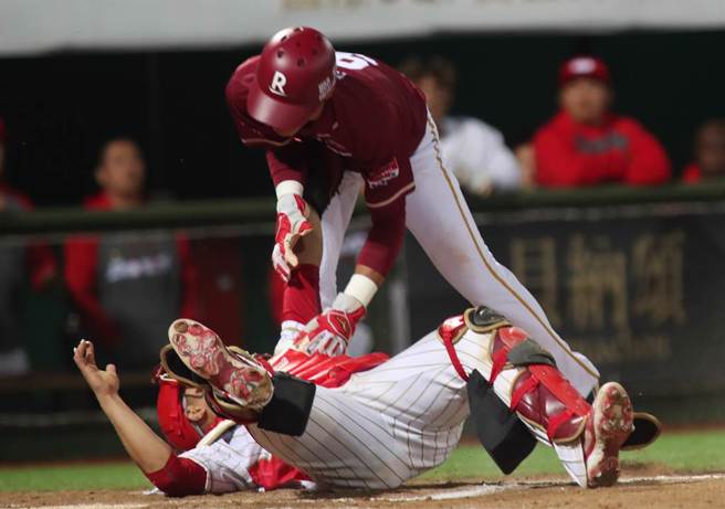 中華職棒15日味全龍對樂天桃猿之戰，桃猿陳晨威7局上藉著安打自2壘直闖本壘，跳在空中企圖躲開接球飛撲欲觸殺的味全捕手吉力吉撈未成，掉落在吉力吉撈的身上遭到觸殺出局。（鄭任南攝）