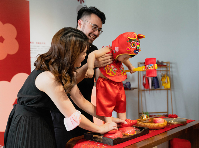 爸妈带着宝宝脚踩红龟，期望孩子长命百岁、多福多寿。(图片提供/旧振南)