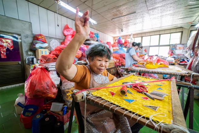 從事刺繡工藝已逾60年的張麗娟，繡針在她手上就像彩筆，一針一線為神明縫製美麗的新衣。(林旻萱攝)
