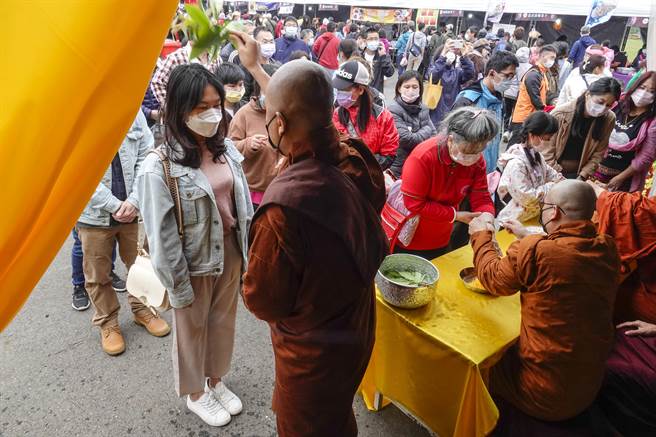 极具异国风情的桃园龙冈米干节16日在龙冈登场，适逢新一波疫情严峻之际，主办单位安排僧侣为民眾打平安手环及洒净祈福，希望让居民早日度过疫情带来的衝击。（黄子明摄）  