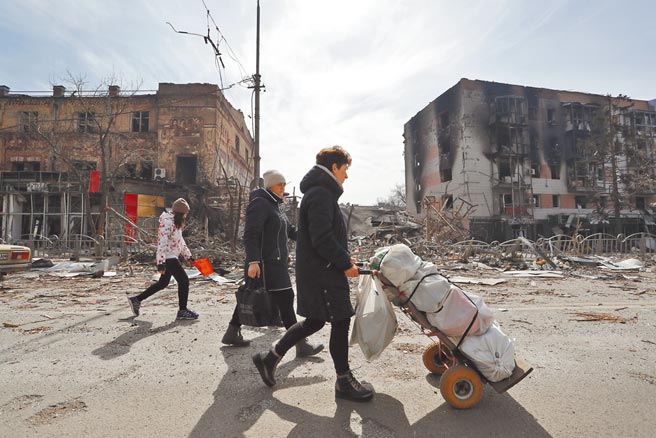俄乌战事已持续50天，乌克兰总统泽伦斯基发表全国谈话，向捍卫乌克兰的人民表示敬意。图为11日马立波居民走在被战火侵袭过的街头。（新华社）