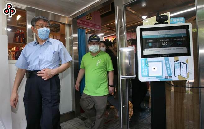 台北市長柯文哲（左）去年前往南門市場視察「市場實聯分流管理資訊站」試辦效果和分流情況。（本報資料照片）