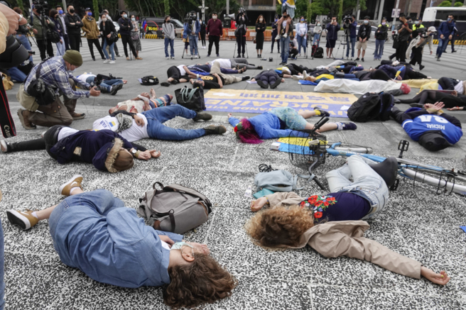 在台乌克兰人及声援团体17日在台北自由广场前举行集会，参与人士躺在地上共同演出集体死亡行动剧，控诉俄罗斯部队入侵乌克兰后屠杀平民的暴行。（黄子明摄）