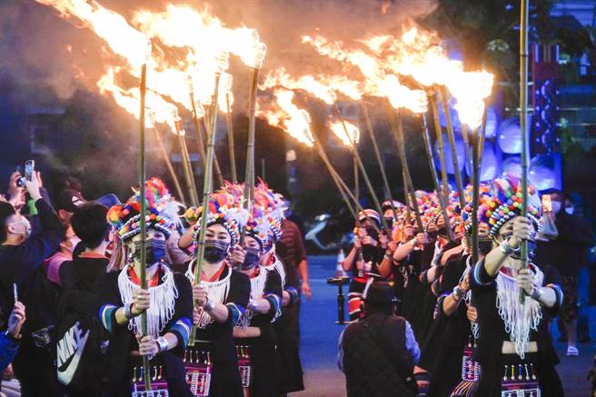 桃园市龙冈米干节17日最后高潮的火把节，由一群穿着云南少数民族传统服饰女子分持数十支火把进场。（黄子明摄）