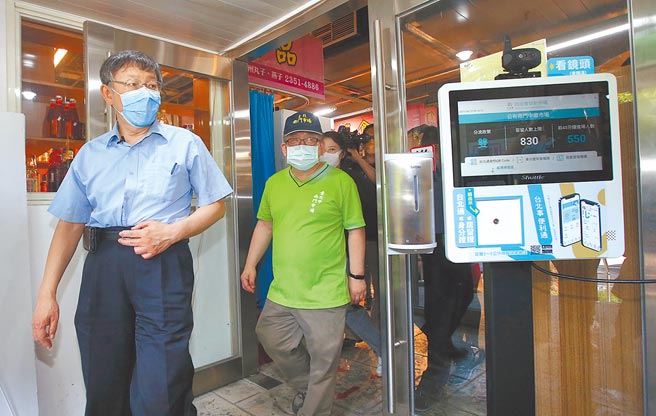 台北市政府去年6月在南门市场试办「实联分流管理资讯站」，管制市场採买人潮避免群聚，市长柯文哲（左）前往视察成效。（本报资料照片）