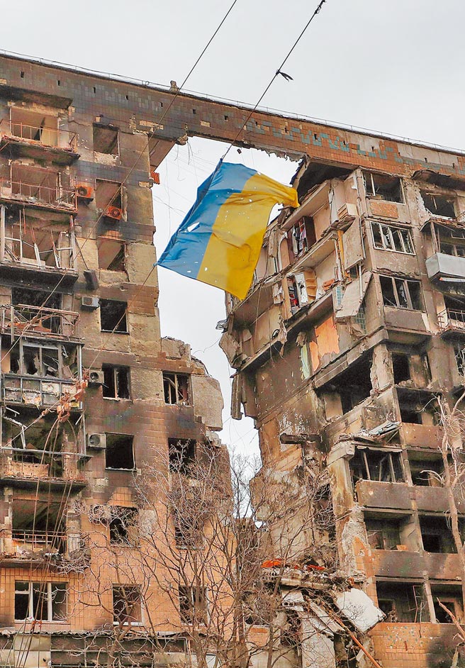 俄罗斯猛攻乌克兰南部港口城市马立波，市区到处是断垣残壁，其中被炸出一个大洞的公寓，残破的乌克兰国旗仍迎风飘扬。（路透）