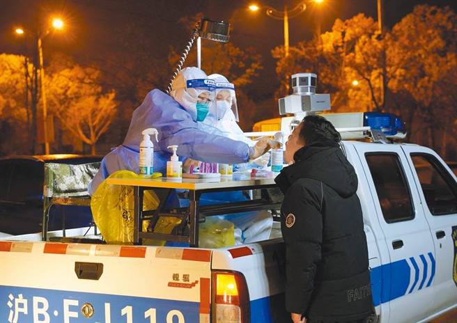 上海市奉賢區的醫務人員在流動採樣車上進行核酸檢測。（圖／新華社）