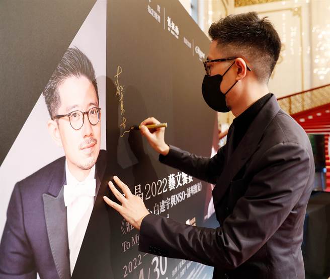 指挥庄东杰(见图)在海报板上签名留念。(陈怡诚摄)