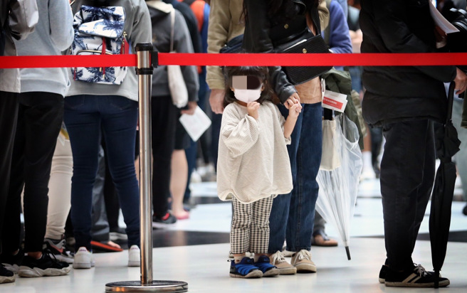 首例重症兒童不幸病故後，家長對於要不要讓幼童打疫苗，仍有不少人存疑。圖為台北車站疫苗接種站，民眾排隊施打疫苗。示意圖非當事人。（資料照／范揚光攝）