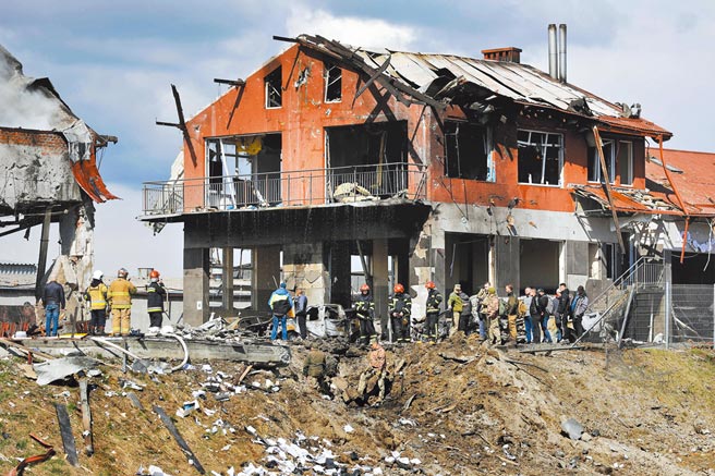 俄罗斯18日轰炸乌克兰西部城市利维夫（Lviv），造成大量建筑物受损，警消人员在断垣残壁中搜救生还者。（路透）