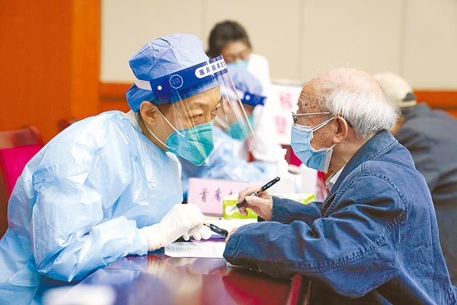 图为2022年4月18日，医护人员为老年人讲解新冠病毒疫苗接种知情同意书。（新华社）