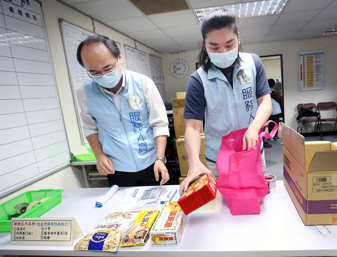 居家隔離人數隨著疫情急速暴增，台北市12個區級關懷中心20日起正式上線，信義區關懷中心工作人員正在準備防疫關懷包給居隔民眾。（范揚光攝）