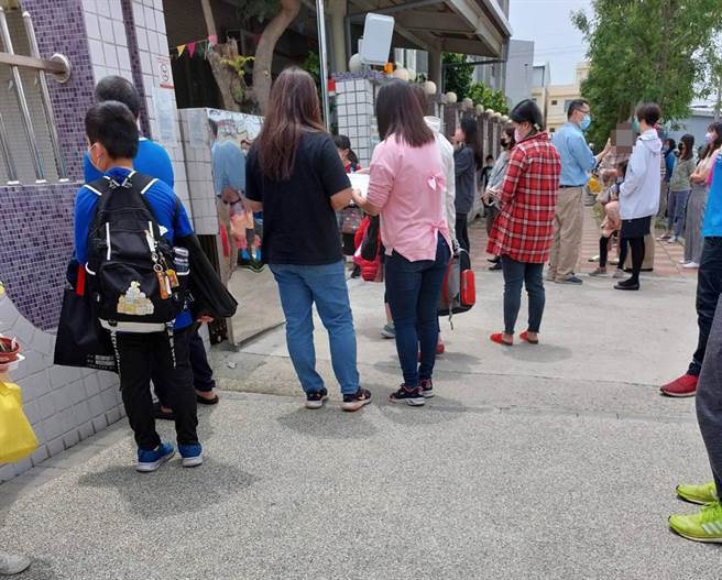 家長於今天中午放學時，於校門口等候接小孩回家。(民眾提供)