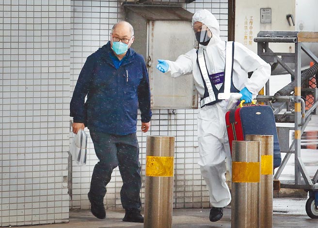 台湾NGO工作者李明哲（左）15日上午搭机返台，班机靠桥后在商务中心人员陪同下，从空桥直接走下机坪搭车离开。（本报资料照片）