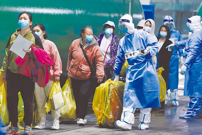 大陸疫情專家吳尊友表示，「動態清零」與追求「零感染」有著本質的區別，不意味一定要全城封控、實施全員核酸普篩。圖為4月14日，上海方艙醫院首批322名患者解除隔離順利出艙，醫護人員幫忙搬運行李。（中新社）