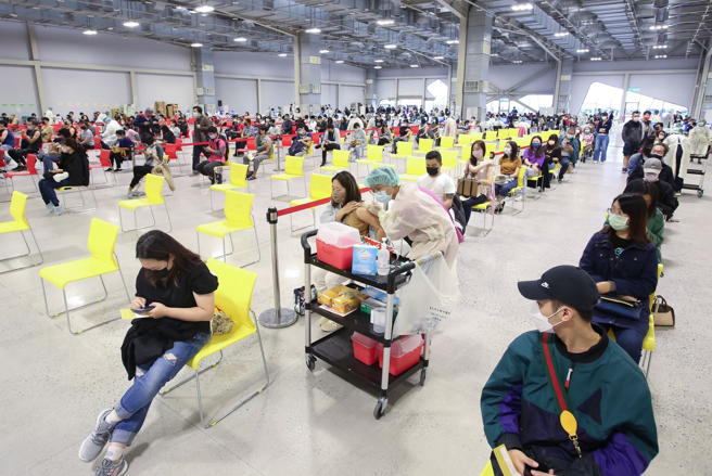 中央疫情指揮中心17日公布新增1210例本土病例。在台北車站施打站等候接種的民眾，從大廳排隊排到戶外廣場。（資料照，鄧博仁攝）