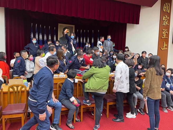 立法院財政委員會今（21日）審查「會計法第99條之1修正草案」，藍綠兩黨攻占主席台。（葉書宏攝）