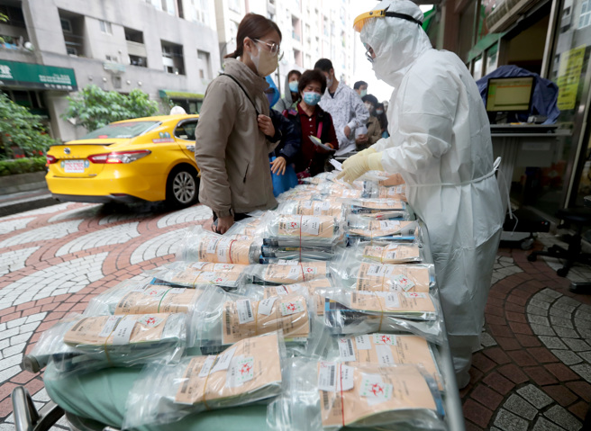 指揮中心放寬居家照護同住家人條件；圖為民眾到汐止國泰醫院的篩檢站領取居家檢疫快篩試劑。（資料照/鄭任南攝）