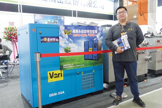 義騰負責人楊承翔和該公司「永磁變頻空壓機」合影。圖／黃俊榮