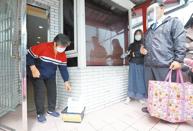 新冠肺炎疫情持续扩大，台北市12个行政区只要是居家治疗的确诊者，电话通知后将由药师送药品到宅。图为位于北市的博医仁爱药局20日由药师示范，将处方药品送至民眾家外。（郑任南摄）