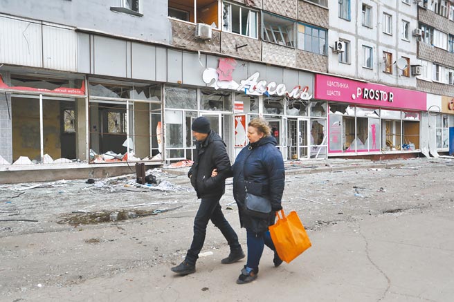 图为4月19日，在马立波，当地居民从被损坏的建筑旁走过。（新华社）