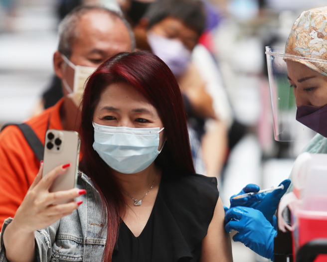 近日疫情升溫，位於台北車站的接種站，有不少民眾前來施打疫苗。（季志翔攝）