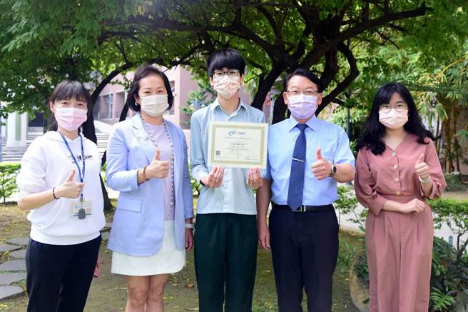 侨泰高中应用英语科三年级陈信谚(中)，多益检定一举夺下950高分成绩，开心与师长合影。(侨泰高中提供／林欣仪台中传真)