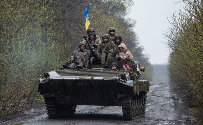 乌克兰部队4月19日搭乘装甲车，行经乌东战区。（路透）
