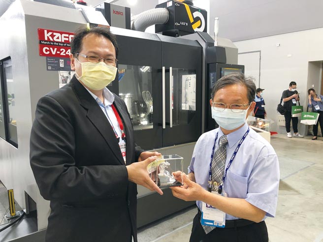 國立新營高工校長黃進雄（右）參訪松立欣展區，松立欣公司副總許哲銘（左）也趁機贈送該公司參展機械切削成品給黃校長。圖／郭文正