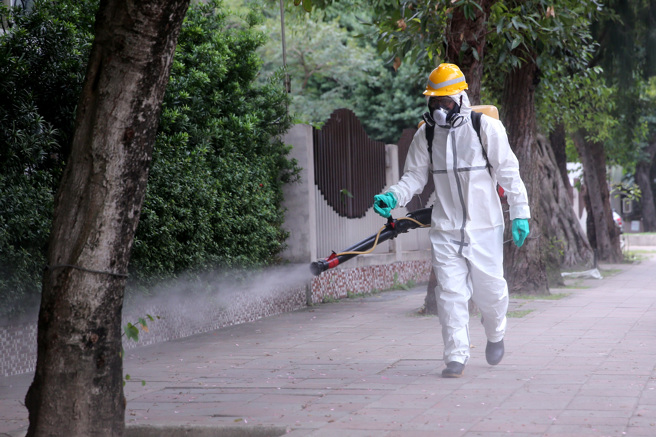 有男网友好奇，大学生的疫苗覆盖率超过九成，为何拼命要求学校实施远距教学，引发讨论。图为消毒人员清消校园周围。（资料照）