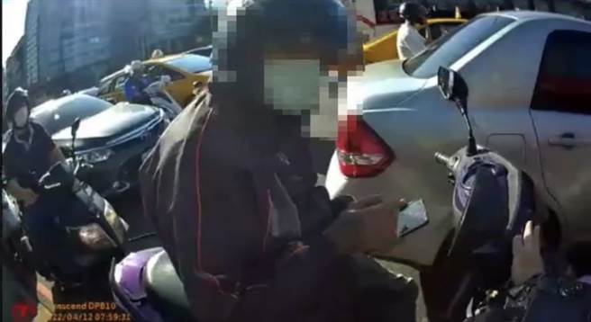 郑男停等红等使用手机遭警方拦查。（警方提供）