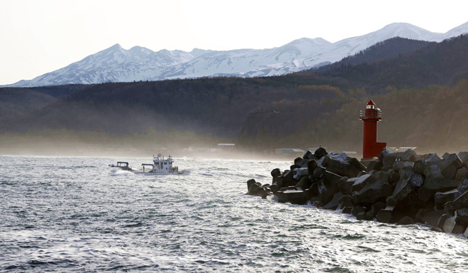 日本北海道觀光船「KAZU 1」23日沉沒，船上26人失聯，日本海上保安總部24日清晨發現4人。圖為漁船在失事海域進行搜救。（圖／美聯社、共同社）