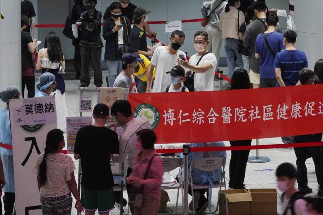 台北松山捷运站接种站24日开放民眾现场登记很快就额满，不肯放弃的晚到民眾，围在管制区外询问工作人员登记事宜；线内线外两样情。（黄子明摄）