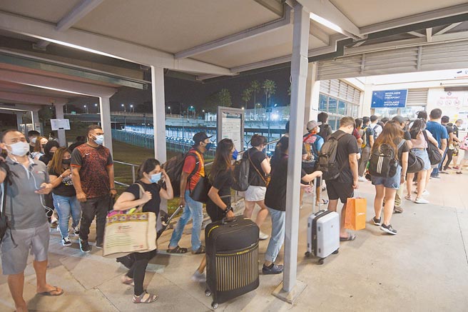 4月1日，旅客准备从新加坡兀兰关卡过境到马来西亚。（新华社）