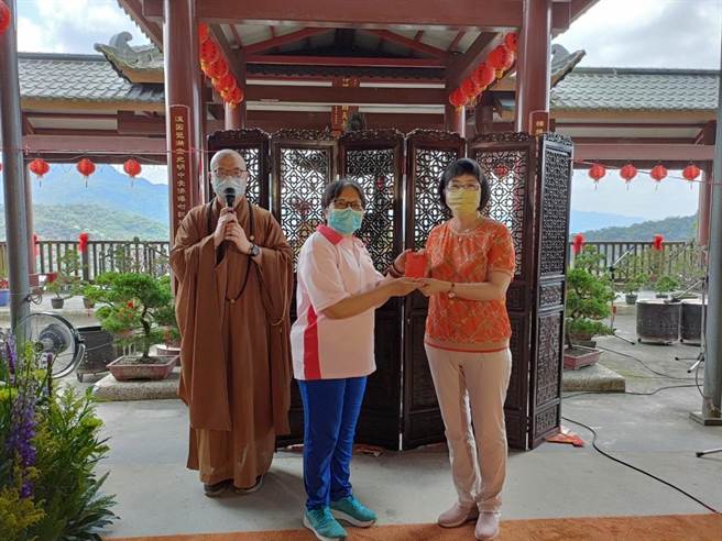 圣慈山慈诚寺副主委吴佳宴（中）代表捐赠新北市爱心大平台防疫基金及急难救助金等共20万元，新北市社会局长张锦丽代表受赠，左为住持常源方丈。（新北市社会局提供）