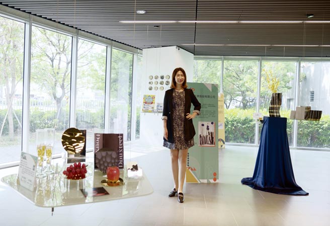 澄茂企業林洧緹總經理，和這次展出的月涼如水盤、峽谷花瓶合影。圖／業者提供